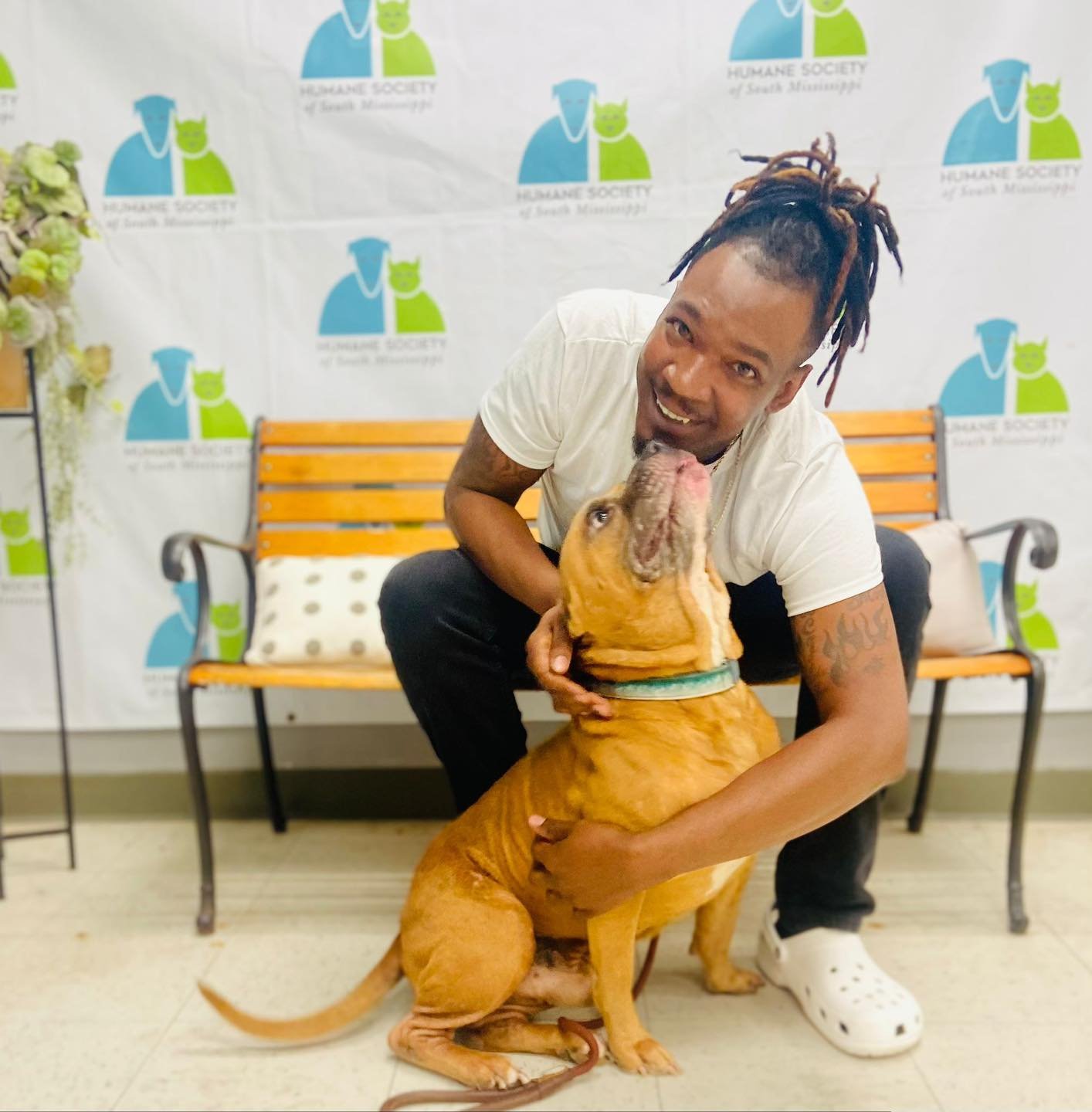 Man smiles while holding dog