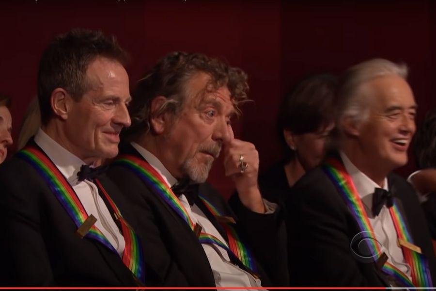 three men watching a performance