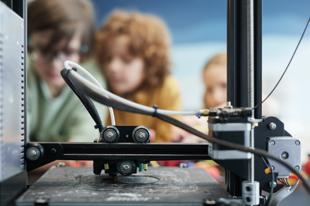 Children looking at a 3D printer