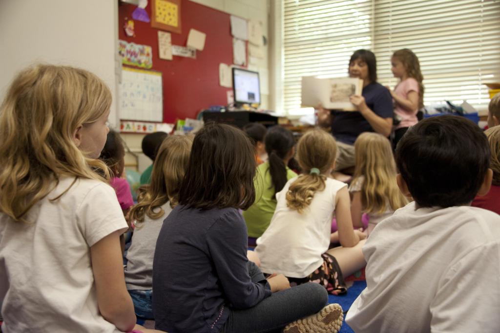 teacher reads to young students