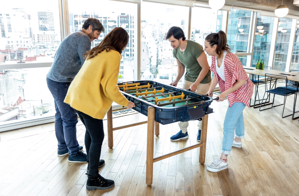 Office workers playing foosball in a high rise building