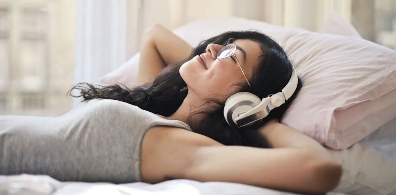 listening to music, learning a skill, woman in bed