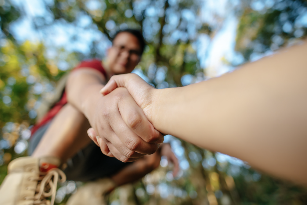 Person offering their hand to lift someone up