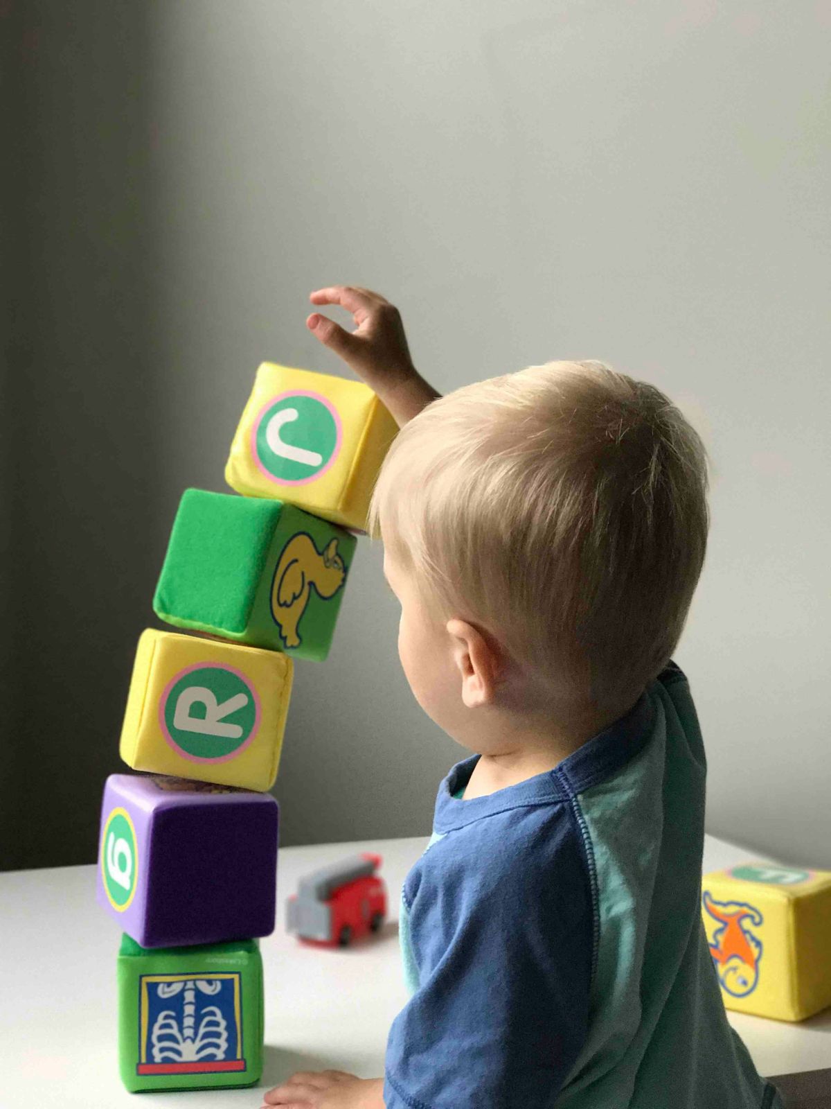 boy playing with blocks on white wooden table