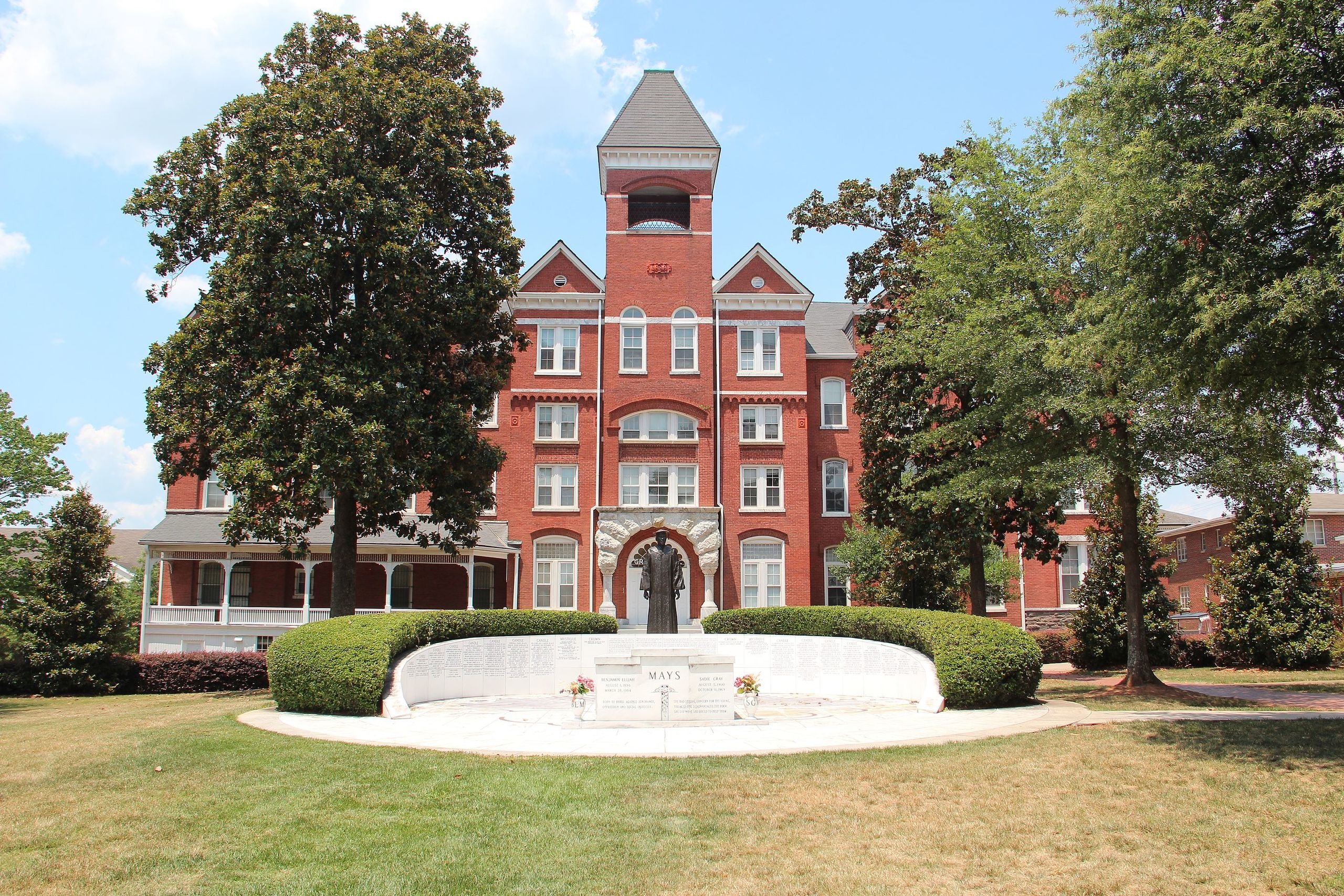 large red-brick building with trees and green lawn