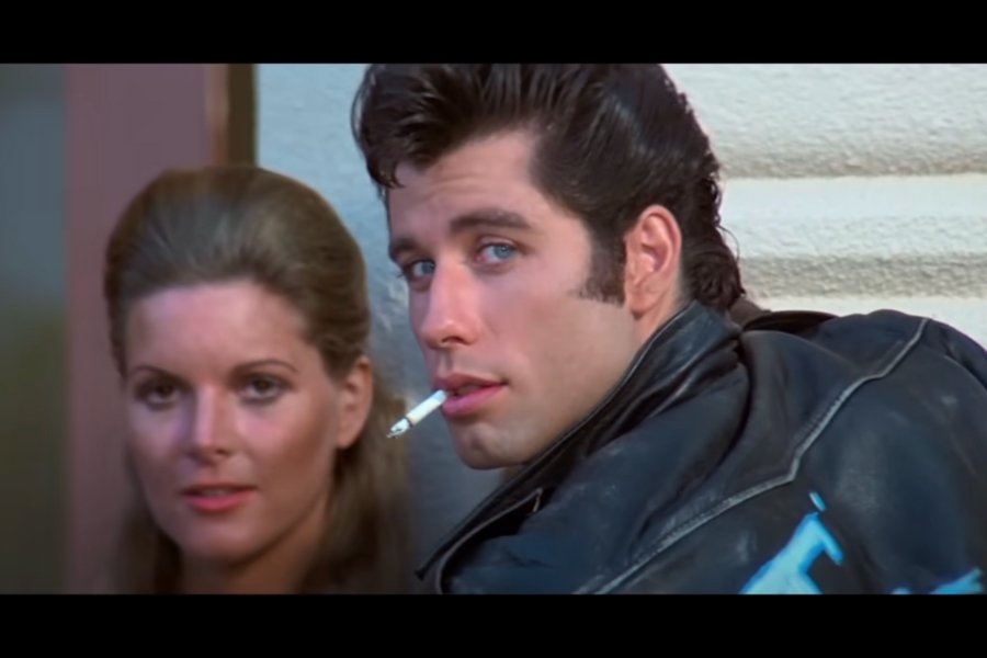 John Travolta as Danny in Grease looks over his shoulder with a cigarette in his mouth