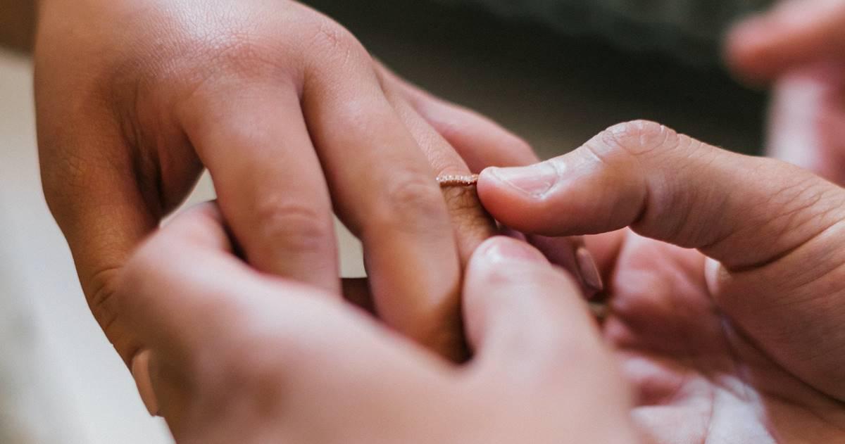 A couple exchanges wedding rings.