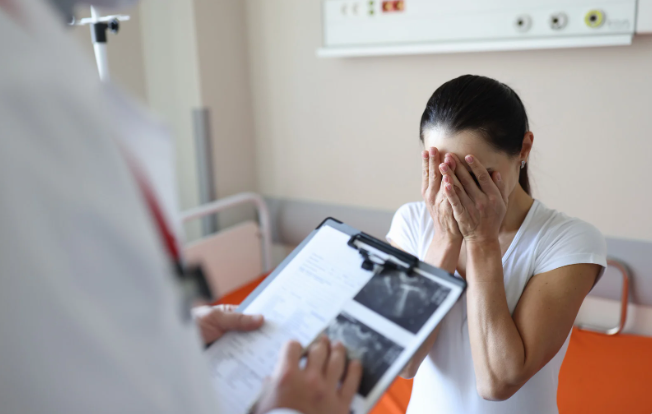 A woman hears bad news at the doctor's office.