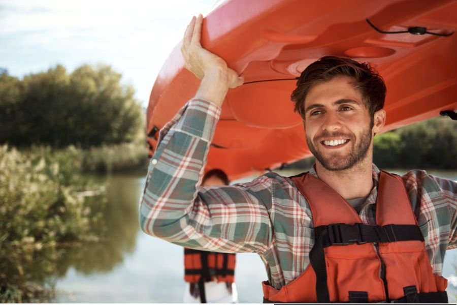 man carrying canoe