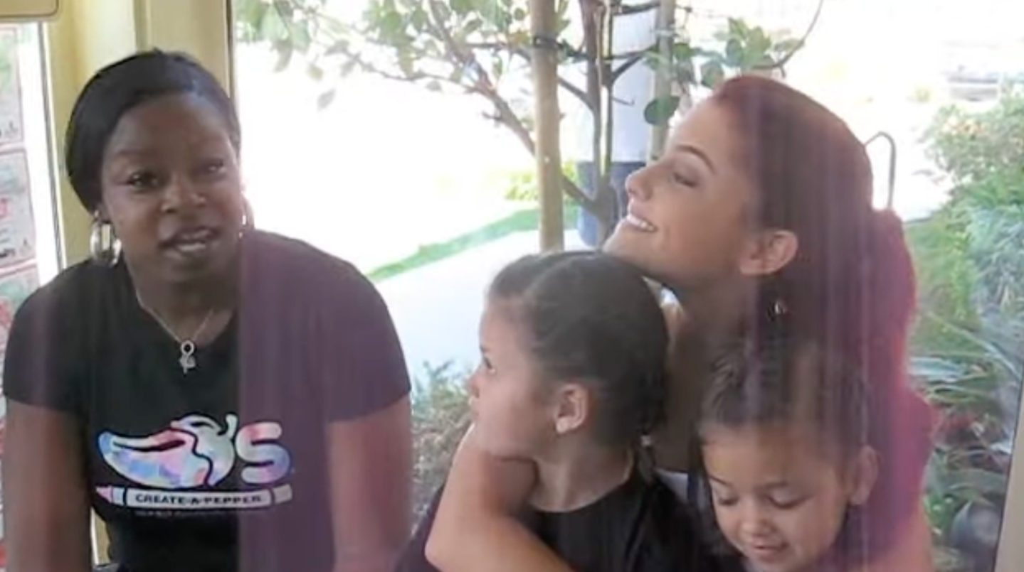 A younger Ariana Grande hugs two kids