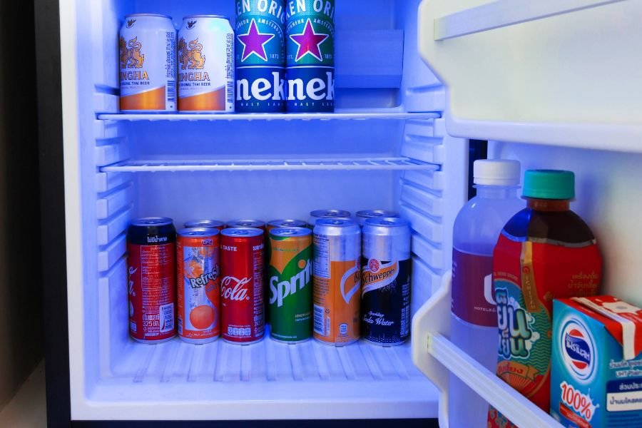 open fridge filled with beer, soda, and juice