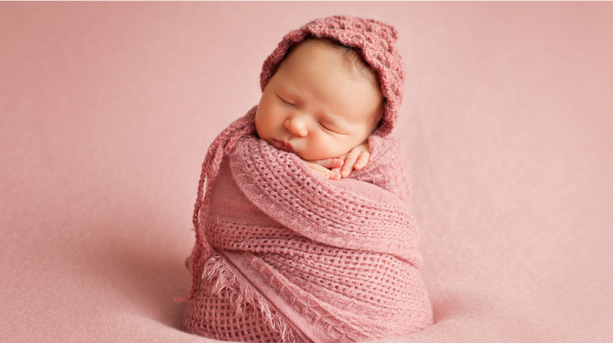 baby swathed in pink blanket 