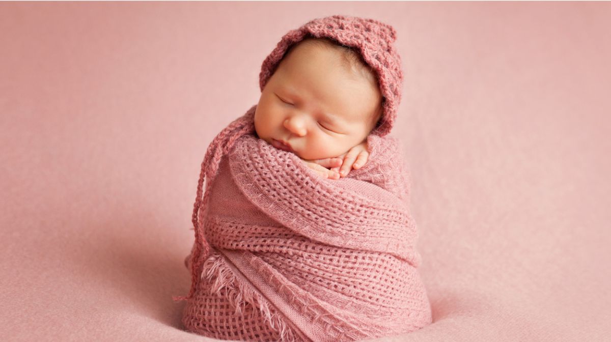 baby swathed in pink blanket