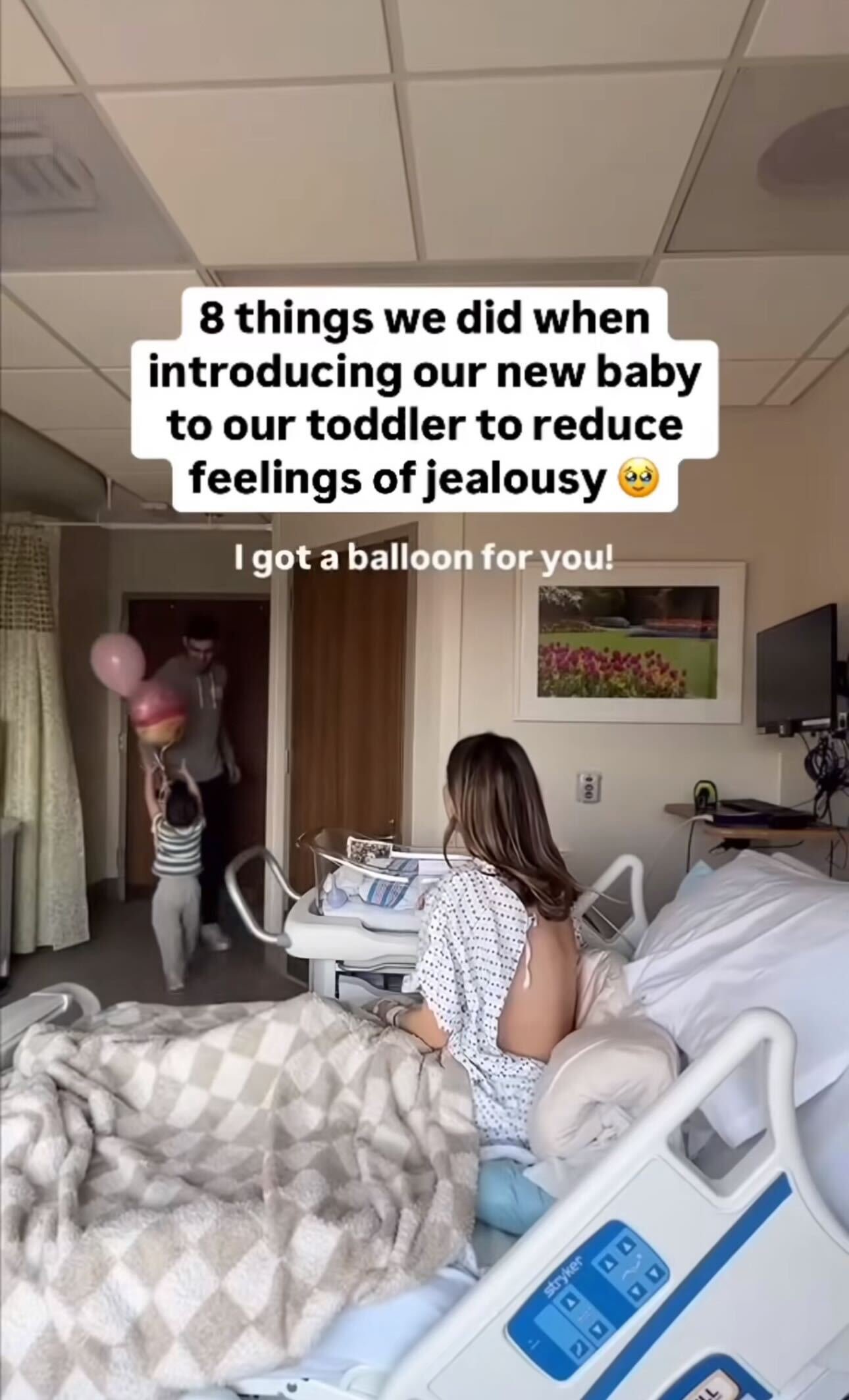 Screenshot, woman in hospital bed with child and adult man in room