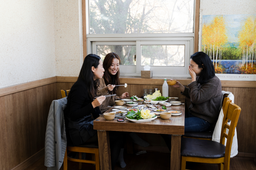 Women, eating, restaurant, smiling, enjoying meal 