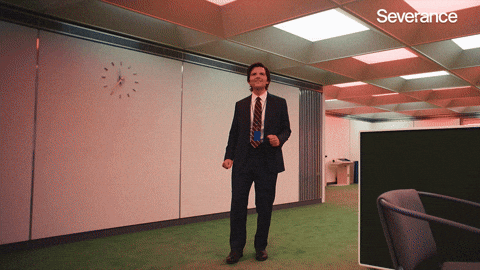 Man joyfully dancing in an office with a clock on the wall, labeled 