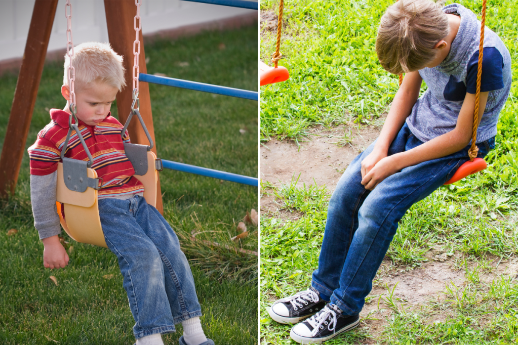Two boys sitting on swings, with heads down, looking thoughtful.
