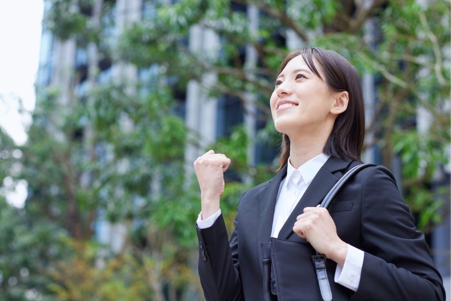 A confident woman in a suit, smiling with a fist pump, exuding confidence, confidence, body language, queues