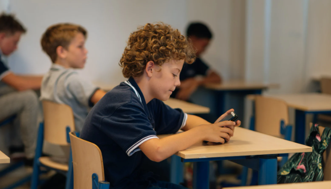 smartphone, student, student cellphone, desk, classroom, staring at phone