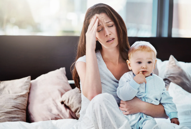 young mom, stressed mom, baby, mom and baby, baby in bed, tired mom