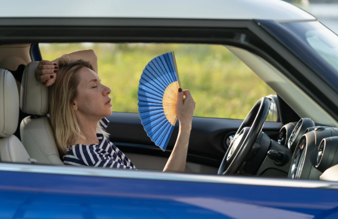 hot car, cool car, woman with fan, summer car, summer heat, sweating,