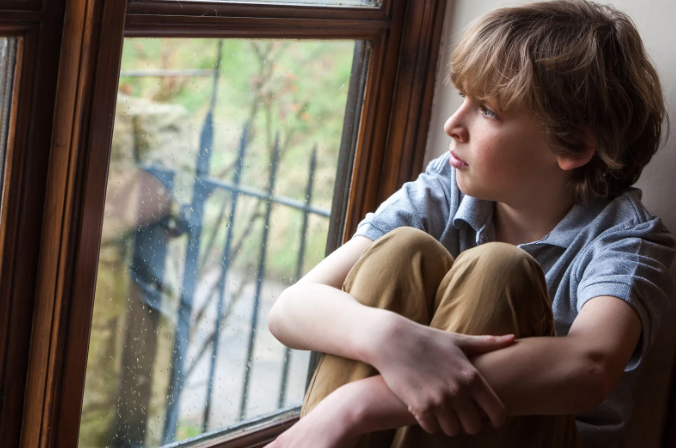 sad child, sheltered child, boy at window, depression, helicopter parent, stuck inside