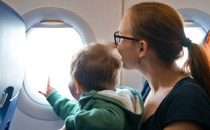 toddler on plane, airplane, plane window, mom and toddler, curious child, airplane seats