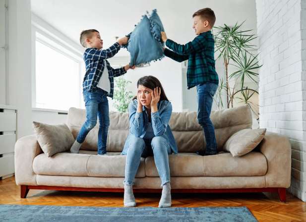 parenting, moms, stressed mom, pillow fight, standing on couch, kids playing,