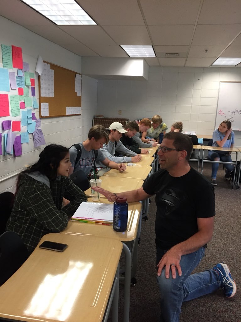 teacher talking to students in a classroom