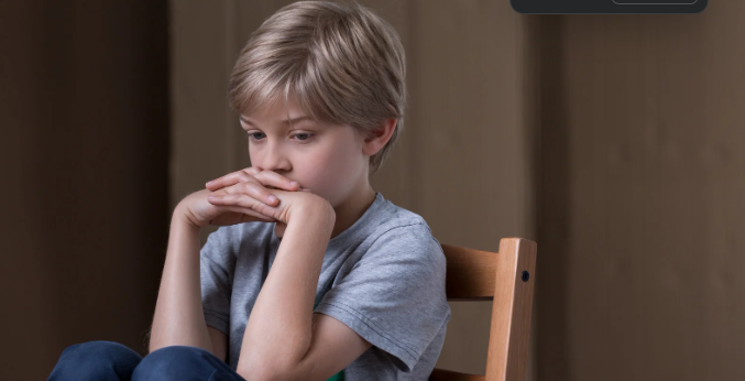 sad child, sad boy, boy hiding, boy hands over mouth, boy in chair, scared boy