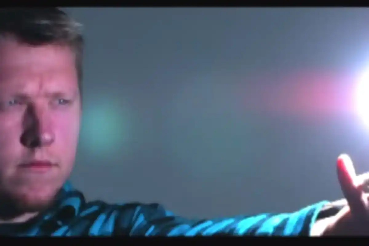 a man holds out his arm toward a ball of light