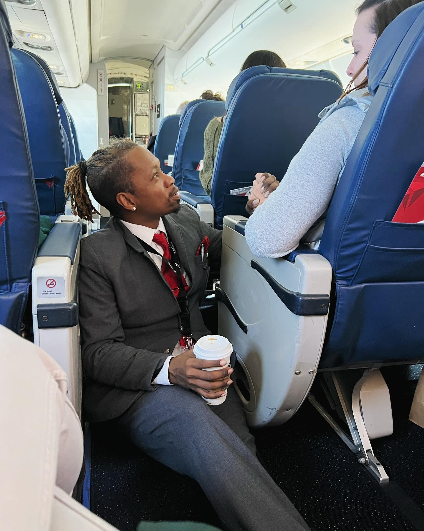 A scared passenger was shaking, so this flight attendant stopped everything to hold her hand