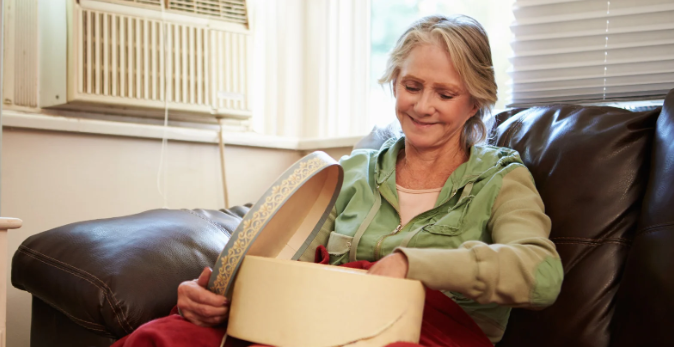 photos, mementos, hat box, middle-aged woman, smile, happy woman