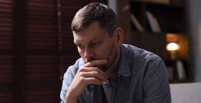 sad man, man with regrets, hand on chin, man in denim shirt, thoughtful man