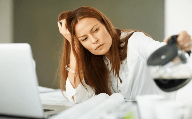 tired woman, coffee work, feeling off, redhead woman, woman at desk,