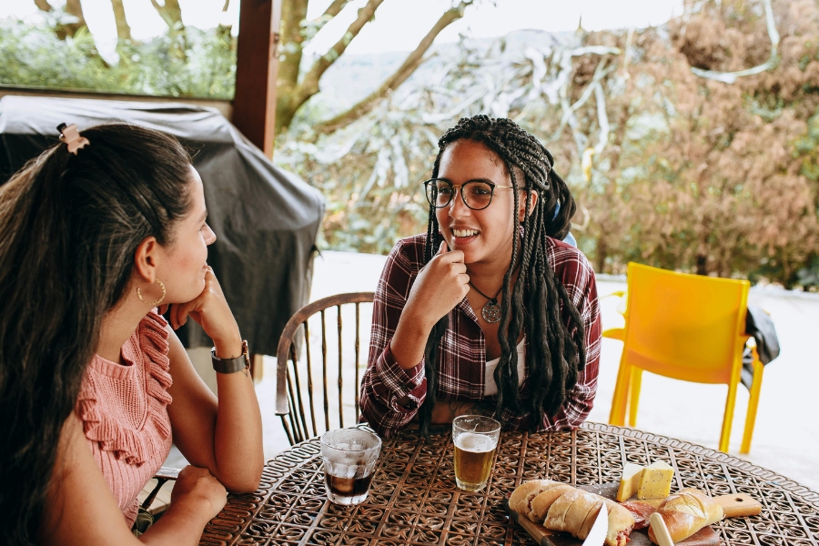 Two women sitting and conversing in an outdoor cafe