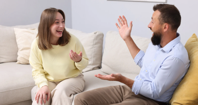 man and woman, people laughing, sitting on couch, good company, jokes
