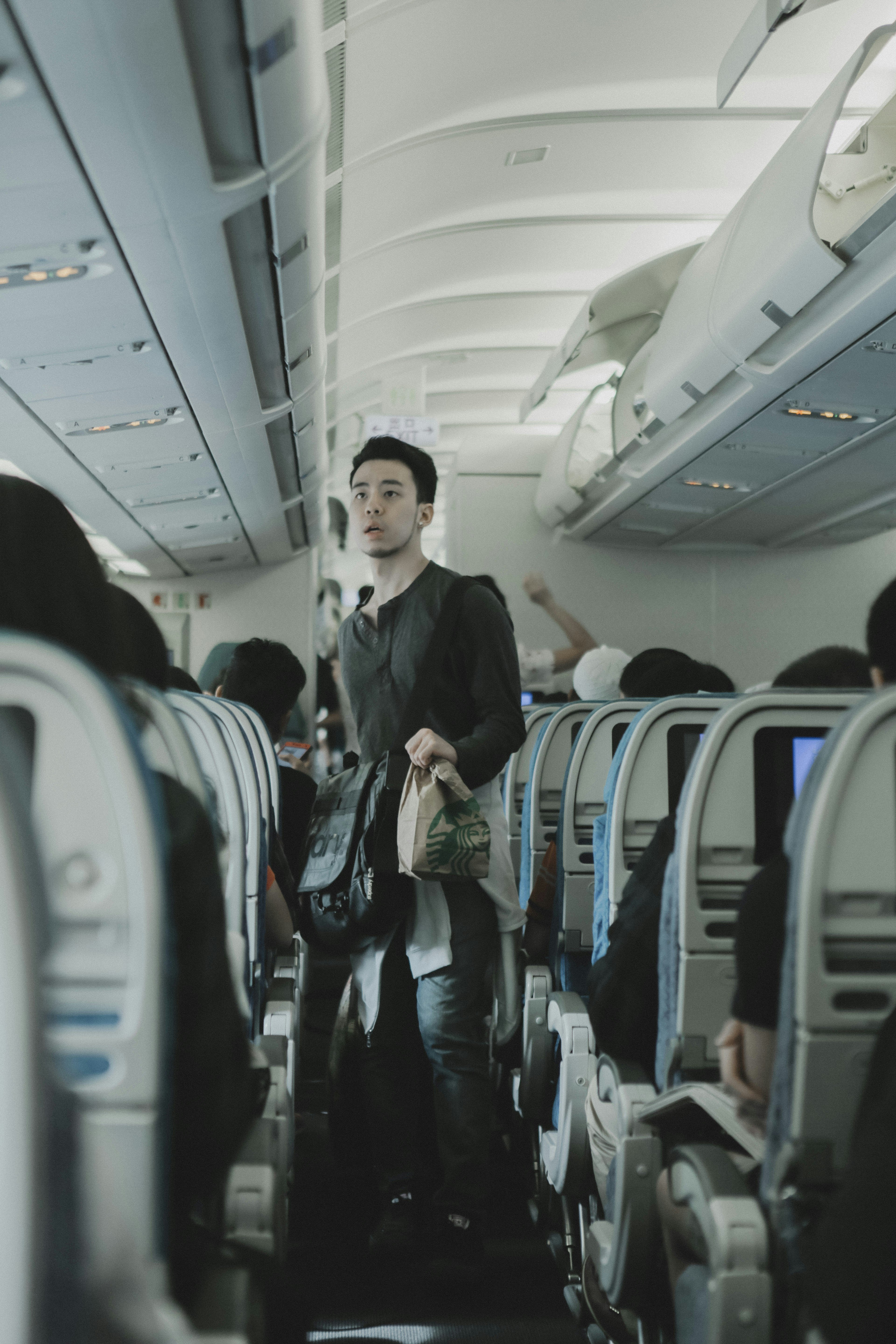 Man walks to his seat on an airplane