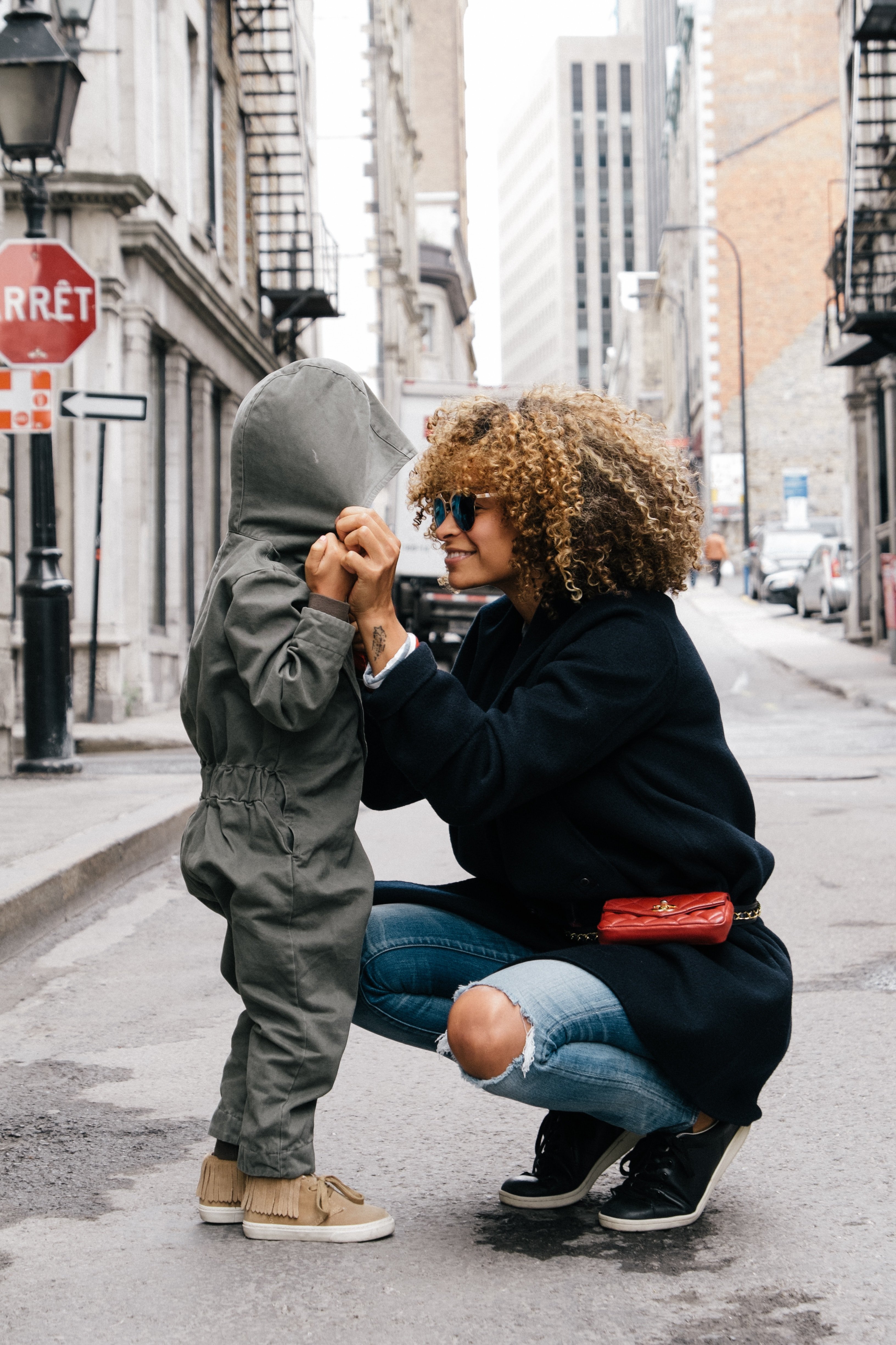 woman holding kid in the street