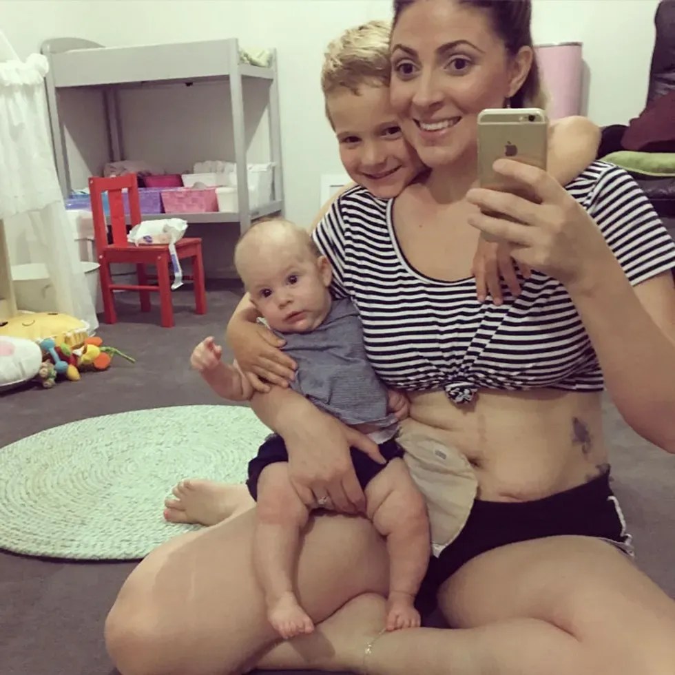 woman takes photo with her two children