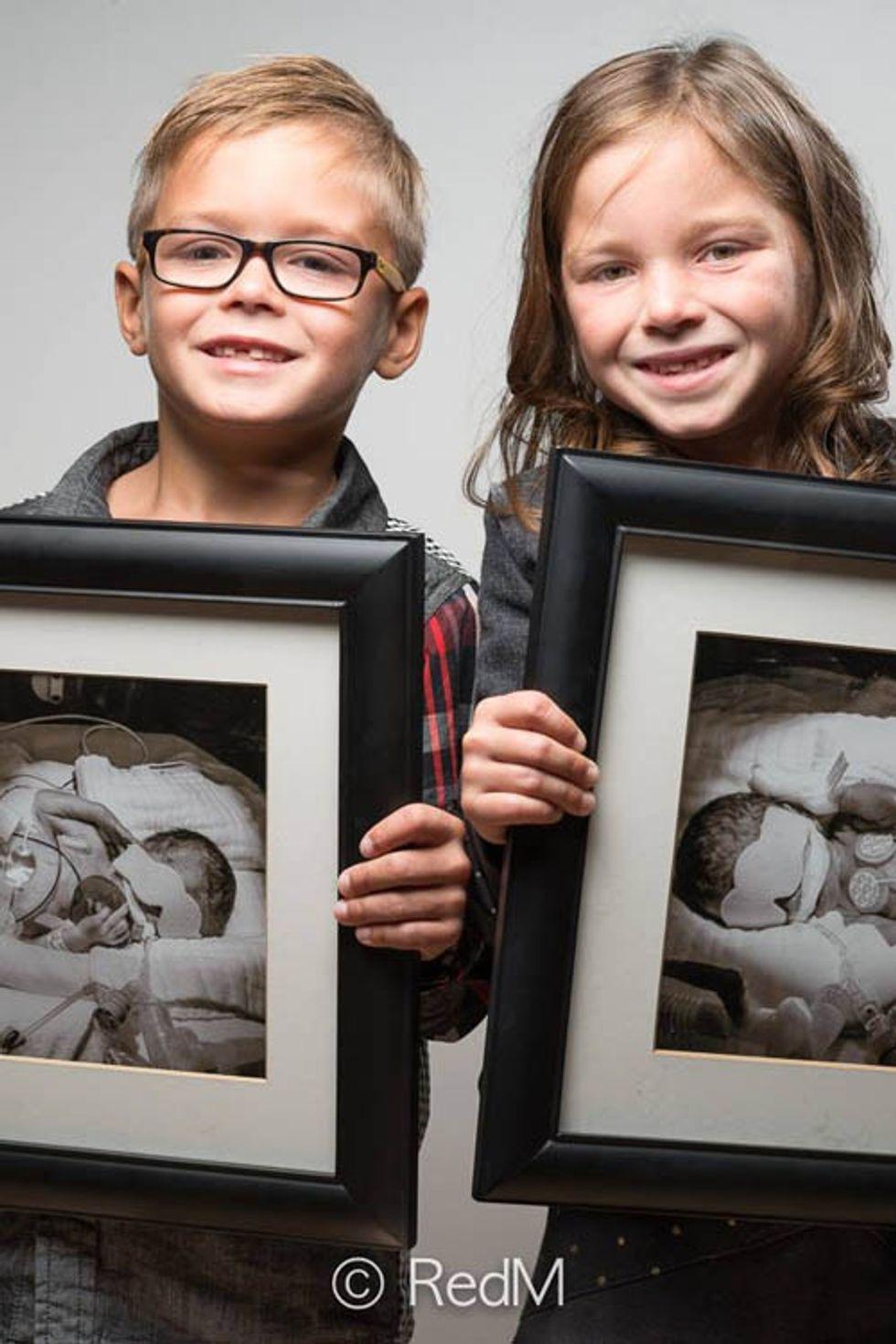 twin siblings hold black and white photo of themselves as premature babies