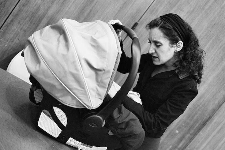Woman looks into a baby carrier