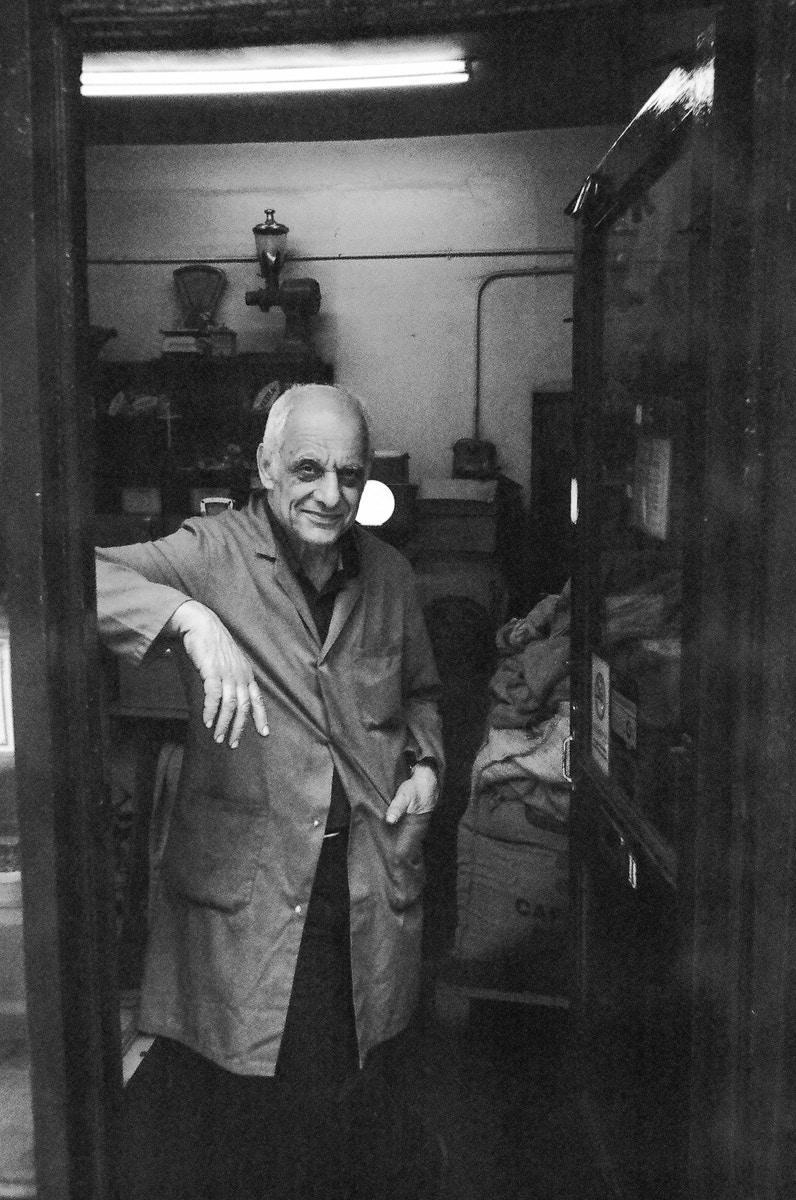 black and white photo of an elderly man in a long coat