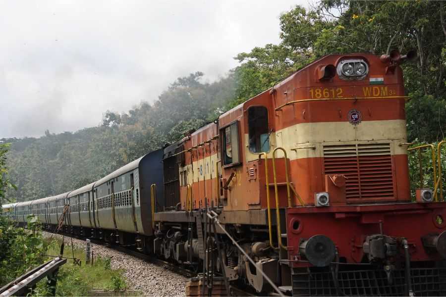 railroad tracks; rocks around train; train; cargo trains; rail road