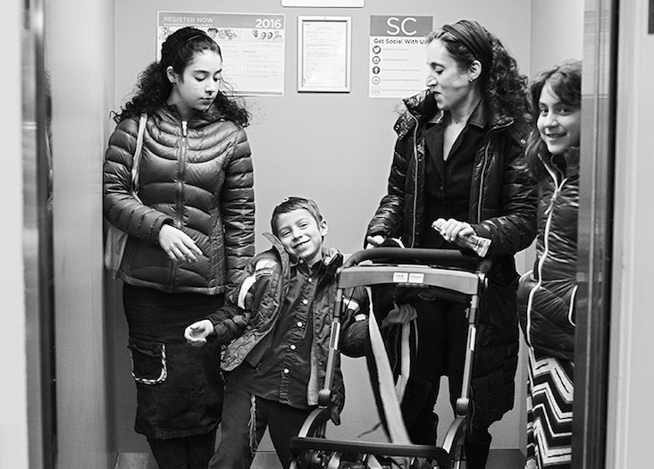 Woman with three children pushes an empty a stroller