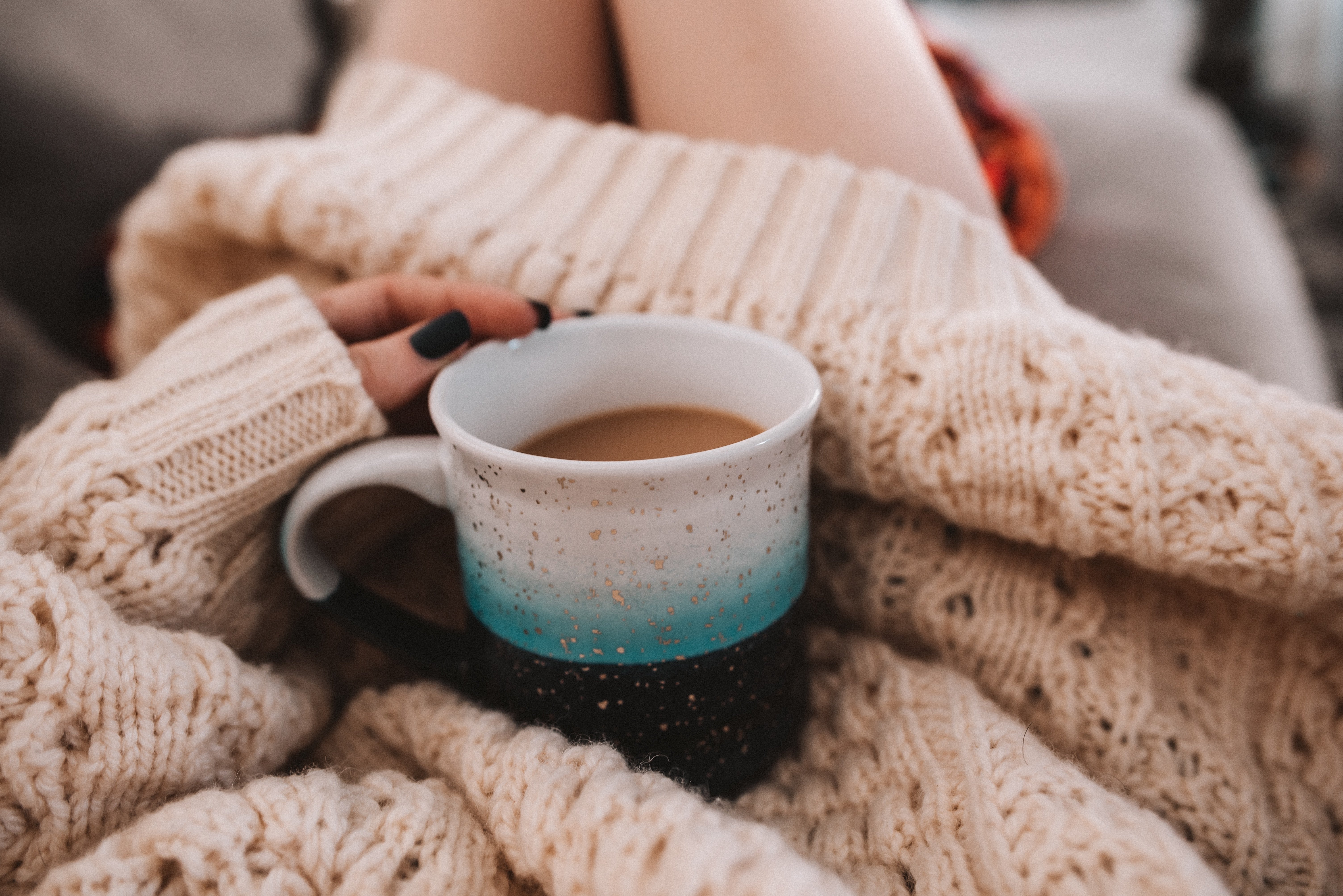 woman in sweater holding a mug