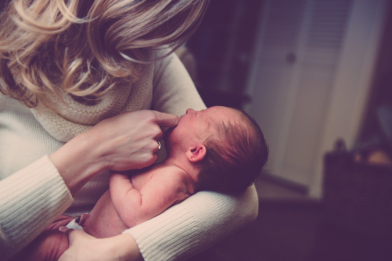 A woman holds a newborn baby.