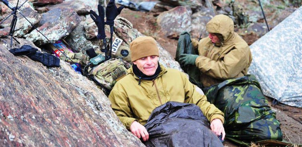 military men in sleeping bags on a mountain