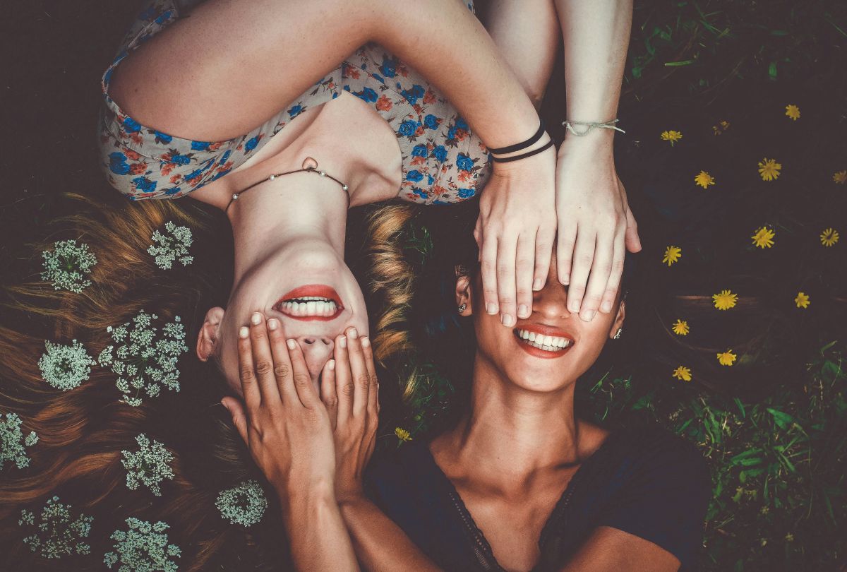 two women with their hands over each other's eyes