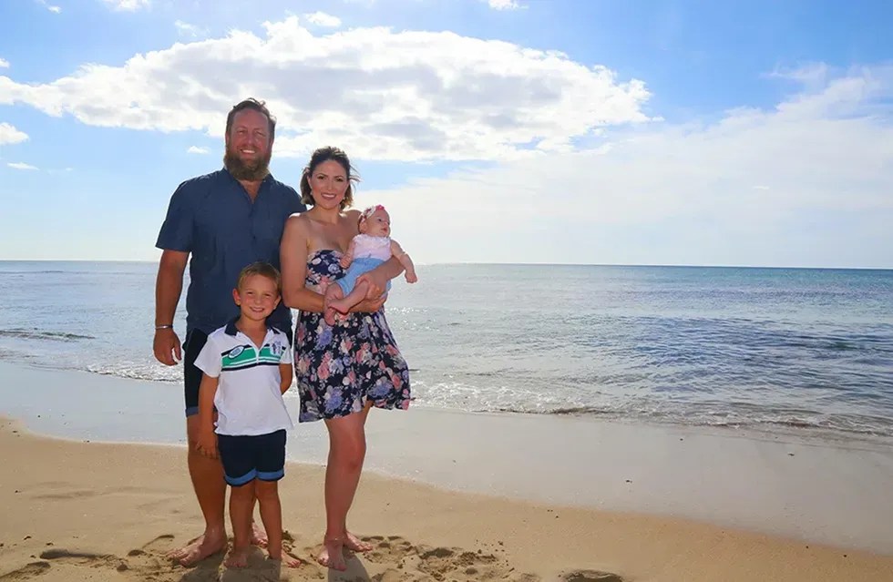 family posing for photo on the beach